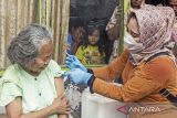 Vaksinator menyuntikkan vaksin COVID-19 saat pelaksanaan vaksinasi lansia pintu ke pintu di Kelurahan Plawad, Karawang, Jawa Barat, Jumat (18/2/2022). Presiden Joko Widodo mengatakan pentingnya percepatan vaksinasi COVID-19 khususnya untuk lansia dan anak dalam pengendalian COVID-19 terutama varian Omicron seiring meningkatnya kasus. ANTARA FOTO/M Ibnu Chazar/agr