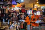 Petugas Badan Nasional Penanggulan Bencana (BNPB) membagikan masker kepada pedagang di Pasar Baru, Bandung, Jawa Barat, Sabtu (19/2/2022). BNPB bersama pemerintah Kota Bandung dan dinas terkait membagikan 200 ribu masker di berbagai titik di Kota Bandung dan Cimahi untuk mengantisipasi lonjakan kasus COVID-19. ANTARA FOTO/Raisan Al Farisi/agr
