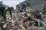 Anggota Satgas Citarum Harum sektor 18 bersama warga memungut sampah saat aksi bersih sampah di wilayah bantaran Sungai Citarum, Desa Anggadita, Karawang, Jawa Barat, Senin (21/2/2022). Aksi bersih sampah oleh Satgas Citarum Harum bersama warga tersebut dalam rangka memperingati Hari Peduli Sampah Nasional (HPSN) sekaligus mengajak warga agar lebih peduli terhadap kebersihan lingkungan. ANTARA FOTO/M Ibnu Chazar/agr