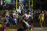 Sejumlah warga menyaksikan penari melakukan aksinya saat Festival Budaya Dayak Maanyan Warukin di Desa Warukin, Kabupaten Tabalong, Kalimantan Selatan, Senin (21/2/2022). Kegiatan yang dilaksanakan pemuda dan pemudi yang diberi kepercayaan oleh lembaga adat Dayak Maanyan Warukin tersebut menampilkan berbagai macam pentas seni tari dan musik tradisional yang bertujuan untuk membangkitkan minat generasi muda terhadap budaya dengan muatan kearifan lokal. Foto Antaranews Kalsel/Bayu Pratama S.