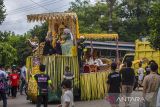 Pengantin menaiki mobil yang di hiasi ornamen naga yang dinamakan Baarak Naga saat Tradisi Pengantin Banjar Di Kecamatan Haruyan, Kabupaten Hulu Sungai Tengah, Kalimantan Selatan, Senin (21/2/2022). Tradisi pengantin tersebut menampilkan berbagai macam seni dan budaya seperti Bearak Naga, Bausung Pengantin, berbalas pantun dan Bapantul yang merupakan adat istiadat suata perkawinan di Kalimantan Selatan serta melestarikan tradisi turun temurun adat Banjar. Foto Antaranews Kalsel/Bayu Pratama S.