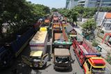 Sejumlah truk berbagai jenis terparkir saat pengemudinya berunjuk rasa di frontage Jalan A Yani, Surabaya, Jawa Timur, Selasa (22/2/2022). Para pengemudi truk itu memprotes aturan terkait over dimension and over loading (ODOL). Antara Jatim/Didik Suhartono