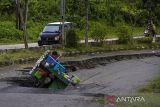 Seorang pengendara motor terjatuh saat melintas di Jalan Nasional Ahmad Yani yang longsor di Kabupaten Balangan, Kalimantan Selatan, Rabu (23/2/2022). Jalan Nasional penghubung antar Provinsi Kalimantan Selatan-Kalimantan Timur tersebut mengalami longsor sejak satu tahun lalu hingga kini belum diperbaiki sehingga dapat membahayakan warga yang melintas di jalan tersebut. Foto Antaranews Kalsel/Bayu Pratama S.