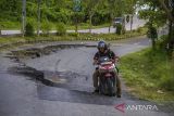 Seorang pengendara motor melintas di Jalan Nasional Ahmad Yani yang longsor di Kabupaten Balangan, Kalimantan Selatan, Rabu (23/2/2022). Jalan Nasional penghubung antar Provinsi Kalimantan Selatan-Kalimantan Timur tersebut mengalami longsor sejak satu tahun lalu hingga kini belum diperbaiki sehingga dapat membahayakan warga yang melintas di jalan tersebut. Foto Antaranews Kalsel/Bayu Pratama S.