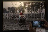 Warga mengamati foto yang dipajang pada pameran foto bertema Mahameru di Surabaya, Jawa Timur, Kamis (24/2/2022). Pameran foto yang memamerkan 50 foto karya 22 fotografer yang tergabung Pewarta Foto Indonesia (PFI) Surabaya itu berlangsung sampai 26 Februari 2022. Antara Jatim/Didik Suhartono