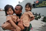 Prajurit Raider TNI mencium anak putrinya jelang pemberangkatan di Pelabuhan Umum Krung Geukuh, Aceh Utara, Aceh, Rabu (23/2/2022). Sebanyak 400 pasukan elite TNI Yonif Raider Khusus 113/Jaya Sakti Aceh diberangkatkan ke Papua untuk menjaga keamanan dan kedaulatan NKRI. ANTARA FOTO/Rahmad