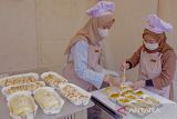 Pelaku usaha menyiapkan roti pesanan pembeli saat Festival Kuliner UMKM di Pasar Bersih, Karawang, Jawa Barat, Sabtu (26/2/2022). Festival yang diikuti oleh sejumlah pelaku usaha kuliner makanan dan minuman itu menjadi ajang promosi dan kreasi kuliner sekaligus upaya membangkitkan UMKM pada masa pandemi COVID-19. ANTARA FOTO/M Ibnu Chazar/agr