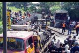 Suasana evakuasi bangkai bus pariwisata PO Harapan Jaya yang tertabrak KA Rapih Doho di perlintasan kereta api tanpa palang pintu di Desa Ketanon, Tulungagung, Jawa Timur, Minggu (27/2/2022). Kecelakaan yang terjadi sekitar pukul 05.00 WIB itu menyebabkan lima dari 43 penumpang termasuk awak bus meninggal dunia dan 14 lainnya luka-luka dan harus dilarikan ke RSUD dr. Iskak Tulungagung untuk mendapat pertolongan kedaruratan medis. ANTARA FOTO/Deny Trisdanto/nym.