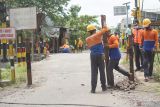 Petugas memasang rambu pancang baja dari potongan rel di bidang jalan dekat perlintasan kereta api tanpa palang pintu di Desa Ketanon, Tulungagung, Jawa Timur, Senin  (28/2/2022). Pemasangan pancang baja di jalur menuju perlintasan kereta api itu bertujuan untuk membatasi kendaraan yang boleh melintas, terutama untuk kendaraan besar seperti truk, bus dan kendaraan roda enam lain agar kecelakaan bus vs KA Dhoho Penataran tidak terulang. Antara Jatim/Destyan Sujarwoko/Ds