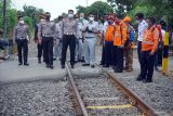 Petugas Korlantas Polri AKBP Tri Yulianto (ketiga kiri) melihat titik lokasi tabrakan KA Rapih Doho Vs bus PO Harapan Jaya di perlintasan kereta api tanpa palang pintu di Desa Ketanon, Tulungagung, Jawa Timur, Senin  (28/2/2022). Polisi menyatakan sebab-sebab kecelakaan yang menewaskan enam penumpang bus dan belasan lainnya luka-luka itu masih terus diselidiki, namun dugaan awal ada unsur kelalaian pengemudi bus yang berkendara di jalur terlarang untuk kendaraan besar. Antara Jatim/Destyan Sujarwoko/Ds