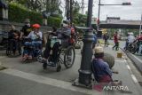Penyandang disabilitas berjalan di trotoar dengan kursi roda di kawasan Dago, Bandung, Jawa Barat, Selasa (1/3/2022). Kegiatan tersebut sebagai bentuk aksi kesadaran kepada pemerintah dan masyarakat tentang kondisi fasilitas publik yang belum cukup ramah dan laik akses untuk penyandang disabilitas dan pengguna kursi roda sekaligus peringatan International Wheelchair Day tiap 1 maret. ANTARA FOTO/Novrian Arbi/agr