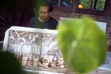 Seniman lukis cethe Adhitya Kreshna menunjukkan salah satu karya lukis yang dibuat menggunakan bahan pewarna endapan kopi di rumah galeri miliknya di Tulungagung, Jawa Timur, Rabu (2/3/2022). Karya lukis cethe bertema 