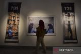 Pengunjung mengamati karya foto yang dipamerkan pada 