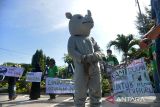 Aktivis dari yayasan HAKA berkolaborasi dengan seniman dan mahasiswa mengenakan badut badak saat aksi peduli satwa di Banda Aceh, Aceh, Jumat (4/3/2022). Aksi kreatif tersebut merupakan kampanye menyuarakan pelestarian  satwa dan mendesak pemerintah serius memberantas pelaku kejahatan perdagangan  ilegal satwa dilindungi di Aceh. ANTARA FOTO/Ampelsa