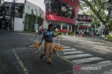 Pedagang buah memikul dagangannya saat berjalan di depan Ciwalk Plaza, Bandung, Jawa Barat, Jumat (4/3/2022). Pemerintah Kota Bandung menyatakan pemulihan ekonomi di Kota Bandung kembali terhambat akibat melonjaknya angka kasus COVID-19 dan status PPKM Level 3 yang berdampak pada pengetatan sektor industri dan perhotelan sehingga memperlambat roda ekonomi pada pendapatan sektor pajak. ANTARA FOTO/Novrian Arbi/agr