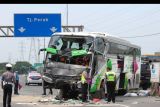 Polisi melakukan pemeriksaan di lokasi kecelakan bus pariwisata dengan truk di Tol Dupak - Tanjung Perak Surabaya, Jawa Timur, Sabtu (5/3/2022). Kecelakaan antara bus pariwisata bernopol D 7610 AT yang memuat rombongan peziarah dengan truk 'Colt Diesel' nomor polisi W 9948 Z itu diduga disebabkan salah satu penumpang bus merebut kendali kemudi dari sopir bus dan menabrak truk 'Colt Diesel' dari arah berlawanan sehingga sopir truk dan kernetnya meninggal dunia di lokasi kecelakaan. ANTARA FOTO/Didik Suhartono/nym.