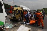 Petugas mengevakuasi jenazah korban kecelakaan bus pariwisata dengan truk di Tol Dupak - Tanjung Perak Surabaya, Jawa Timur, Sabtu (5/3/2022). Kecelakaan antara bus pariwisata bernopol D 7610 AT yang memuat rombongan peziarah dengan truk 'Colt Diesel' nomor polisi W 9948 Z itu diduga disebabkan salah satu penumpang bus merebut kendali kemudi dari sopir bus dan menabrak truk 'Colt Diesel' dari arah berlawanan. Dalam kecelakaan itu sopir truk dan kernetnya meninggal di lokasi kecelakaan. Antara Jatim/Didik Suhartono/zk