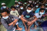 Sejumlah pengungsi etnis Rohingya beristirahat di balai Desa Alue Buya Pasie, Jangka, Kabupaten Bireuen, Aceh, Senin (7/3/2022). Sebanyak 114 orang etnis Rohingya yang terdiri dari 58 laki-laki, 21 perempuan dan 35 anak-anak yang terdampar di perairan Jangka Bireuen pada Minggu (6/7/2022) itu masih menunggu rapat koordinasi antara UHNCR, IOM dengan pemerintah daerah terkait relokasi etnis Rohingya ke tempat penampungan sementara di Aceh. ANTARA FOTO/Rahmad