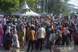 Sejumlah warga antre berbelanja bahan pokok saat berlangsung pasar murah di Pasar Al-Mahirah, Banda Aceh, Aceh, Selasa (15/3/2022). Pasar murah yang berlangsung hingga 18 Maret 2022 menyediakan bahan pangan, beras, minyak goreng, gula pasir dan telur ayam dengan subsidi harga Rp100 ribu per paket itu, sempat menuai protes dar warga yang tidak mendapat kupon berbelanja karena membeludaknya pengunjung dan selain pasar murah tidak tepat sasaran yang seharusnya  memprioritaskan warga tidak mampu . ANTARA FOTO/Ampelsa