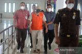 Petugas menggiring buronan kasus korupsi pembangunan dermaga di Nusa Tenggara Timur (NTT , Ramlan (tengah) saat rilis penangkapan di Kejaksaan Tinggi Aceh, Banda Aceh, Rabu (16/3/22). Tim Kejati Aceh, menangkap Ramlan yang telah menjadi buronan sejak 2016 di Banda Aceh, semenjak putusan kasasi Mahkamah Agung atas kasus korupsi pembangunan dermaga di NTT dengan anggaran sebesar Rp20,5 miliar dan kerugian negara Rp4,37 miliar. ANTARA FOTO/Ampelsa