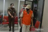 Petugas menggiring buronan kasus korupsi pembangunan dermaga di Nusa Tenggara Timur (NTT , Ramlan (tengah) saat rilis penangkapan di Kejaksaan Tinggi Aceh, Banda Aceh, Rabu (16/3/22). Tim Kejati Aceh, menangkap Ramlan yang telah menjadi buronan sejak 2016 di Banda Aceh, semenjak putusan kasasi Mahkamah Agung atas kasus korupsi pembangunan dermaga di NTT dengan anggaran sebesar Rp20,5 miliar dan kerugian negara Rp4,37 miliar. ANTARA FOTO/Ampelsa