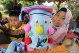 Sejumlah pelajar membuat mainan anak dari kaleng bekas dan kain perca di Sekolah Alam Ramadhani, Kelurahan Mojoroto, Kota Kediri, Jawa Timur, Selasa (15/2/2022). Pelatihan pembuatan berbagai jenis mainan anak dengan memanfaatkan barang bekas tersebut guna mengurangi jumlah sampah di lingkungan sekitar sekaligus mengasah kreativitas anak. Antara Jatim/Prasetia Fauzani/zk