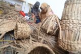 Perajin mengayam tanaman enceng gondok kering sebagai proses pembuatan vas bunga di Desa Paron, Kediri, Jawa Timur, Sabtu (19/3/2022). Kerajinan vas bunga ramah lingkungan tersebut dijual melalui media sosial dengan harga Rp20.000 hingga Rp40.000 per buah tergantung model dan ukuran. Antara Jatim/Prasetia Fauzani/zk