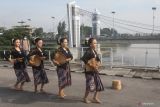 Sejumlah remaja menari saat peringatan berdirinya Jembatan Lama Kediri (Brug Over Den Brantas te Kediri) di Kota Kediri, Jawa Timur, Jumat (18/3/2022). Pertunjukan tari yang diakhiri dengan makan bersama 153 nasi takir tersebut guna memperingati 153 tahun berdirinya Jembatan Lama Kediri yang merupakan jembatan cagar budaya berkonstruksi besi pertama di pulau Jawa. Antara Jatim/Prasetia Fauzani/zk