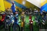 Pekerja museum menata koleksi motor jenis moped  yang dipajang di Museum Motor Klasik SMK Nasional Media Center (NMC) Malang, Jawa Timur, Senin (21/3/2022). Sedikitnya 400 koleksi motor yang diproduksi tahun 1930 hingga 1990 dipamerkan pada museum itu. Antara Jatim/Ari Bowo Sucipto/zk
