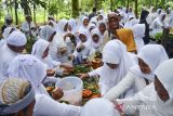 Warga menikmati sajian nasi tumpeng usai ziarah ke makam KH Eyang Penghulu Gusti pada tradisi adat Nyepuh, Desa Ciomas, Kecamatan Panjalu, Kabupate Ciamis, Jawa Barat, Senin (21/3/2022). Tradisi Nyepuh yang sudah berlangsung secara turun temurun tersebut merupakan upacara adat warga Desa Ciomas untuk mensucikan diri lahir dan batin sebelum melaksanakan ibadah puasa di bulan suci Ramadhan. ANTARA FOTO/Adeng Bustomi/agr