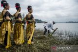 Budayawan Mas Nanu Muda mengambil air menggunakan bambu saat ritual upacara Tradisi Ngalokat Cai di Situ Cileunca, Pangalengan, Kabupaten Bandung, Jawa Barat, Selasa (22/3/2022). Tradisi tersebut sebagai bentuk rasa syukur atas keberadaan air yang melimpah untuk manfaat bagi kehidupan sekaligus menjadi peringatan Hari Air Sedunia 2022. ANTARA FOTO/Novrian Arbi/agr
