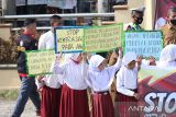 Murid SD bersama para guru di Kota Subulussalam, Aceh, membagikan bunga dan stiker kepada pelintas dalam kampanye stop kekerasan terhadap anak di depan lapangan Beringin, Kota Subulussalam, Selasa (22/3/2022). ANTARA/Fakhrul Razi Anwir