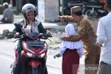 Murid SD bersama para guru di Kota Subulussalam, Aceh, membagikan bunga dan stiker kepada pelintas dalam kampanye stop kekerasan terhadap anak di depan lapangan Beringin, Kota Subulussalam, Selasa (22/3/2022). ANTARA/Fakhrul Razi Anwir