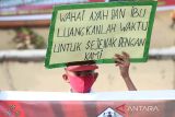 Murid SD bersama para guru di Kota Subulussalam, Aceh, membagikan bunga dan stiker kepada pelintas dalam kampanye stop kekerasan terhadap anak di depan lapangan Beringin, Kota Subulussalam, Selasa (22/3/2022). ANTARA/Fakhrul Razi Anwir