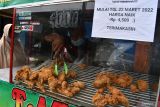 Pedagang ayam goreng melayani pembeli di Pasar Pagotan, Kabupaten Madiun, Jawa Timur, Rabu (23/3/2022). Pedagang tersebut menaikkan harga jual ayam goreng dari Rp4.000 menjadi Rp4.500 per potong akibat kelangkaan dan tingginya harga minyak goreng yang di kawasan pasar tersebut stok minyak goreng curah kosong sejak lima hari lalu, sedangkan minyak goreng kemasan tersedia dengan harga Rp48 ribu per kemasan botol dua liter, Rp25 ribu per kemasan botol satu liter dan Rp23 ribu per kemasan plastik satu liter. Antara Jatim/Siswowidodo/zk