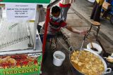 Pedagang menggoreng ayam di Pasar Pagotan, Kabupaten Madiun, Jawa Timur, Rabu (23/3/2022). Pedagang tersebut menaikkan harga jual ayam goreng dari Rp4.000 menjadi Rp4.500 per potong akibat kelangkaan dan tingginya harga minyak goreng yang di kawasan pasar tersebut stok minyak goreng curah kosong sejak lima hari lalu, sedangkan minyak goreng kemasan tersedia dengan harga Rp48 ribu per kemasan botol dua liter, Rp25 ribu per kemasan botol satu liter dan Rp23 ribu per kemasan plastik satu liter. Antara Jatim/Siswowidodo/zk