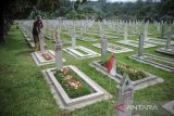 Petugas memasang bendera merah putih di makam pahlawan yang berjuang pada peristiwa Bandung Lautan Api di Taman Makam Pahlawan Nasional, Cikutra, Bandung, Jawa Barat, Rabu (23/3/2022). Setiap tanggal 23 Maret warga Kota Bandung memperingati peristiwa Bandung Lautan Api yang terjadi pada tahun 1946 sebagai peristiwa yang bersejarah. ANTARA FOTO/Raisan Al Farisi/agr