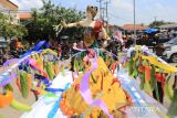 Perangkat desa membawa patung Dewi Sri saat acara adat Mapag Sri di Desa Juntinyuat, Indramayu, Jawa Barat, Rabu (23/3/2022). Tradisi Mapag Sri tersebut biasa digelar sebelum musim panen raya sebagai bentuk ungkapan rasa syukur para petani menyambut musim panen padi. ANTARA FOTO/Dedhez Anggara/agr
