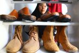 Perajin menata sepatu kombinasi rajut dan kulit buatannya sebelum dikirim ke konsumennya di  Jerman, Malaysia dan Korea Selatan di rumah produksi Eurika Crochet & Leather, Malang, Jawa Timur, Rabu (23/3/2022). Perajin sepatu kulit dan rajut tersebut berupaya memperluas jangkauan pemasaran serta meningkatkan penjualan produknya ke luar negeri dengan memperbanyak siaran langsung di pasar digital yang menyediakan akses ekspor. Antara Jatim/Ari Bowo Sucipto/zk