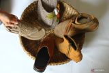 Perajin menata produk sepatu kombinasi rajut dan kulit buatannya untuk dipotret serta diunggah ke pasar digital yang menyediakan akses ekspor di rumah produksi Eurika Crochet & Leather, Malang, Jawa Timur, Rabu (23/3/2022). Perajin sepatu kulit dan rajut tersebut berupaya memperluas jangkauan pemasaran serta meningkatkan penjualan produknya ke luar negeri dengan memperbanyak siaran langsung di pasar digital yang menyediakan akses ekspor. Antara Jatim/Ari Bowo Sucipto/zk