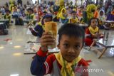 Siswa PAUD menunjukan olahan makanan ikan saat kampanye gerakan cinta rupiah dan makan ikan massal di Gedung Kesenian, Kabupaten Ciamis, Jawa Barat, Kamis (24/3/2022). Gerakan cinta rupiah dan makan ikan massal yang diikuti 200 peserta itu bertujuan untuk mencegah stunting dan mengajak anak mencintai rupiah sejak dini. ANTARA FOTO/Adeng Bustomi/agr