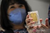 Direktur PT Hartadinata Abadi Sandra Sunanto menunjukkan emas murni 100 gram di gerai emas Hartadinata Abadi di Bandung, Jawa Barat, Jumat (25/3/2022). PT Aneka Tambang Tbk mencatat, penjualan emas pada akhir 2021 mencapai Rp38,44 triliun meningkat 40,45 persen year on year dibandingkan pada akhir 2020 dengan nilai Rp27,37 triliun. ANTARA FOTO/Raisan Al Farisi/agr