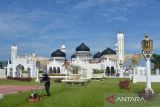 Pekerja memotong rumput di halaman Masjid Raya Baiturrahman, Banda Aceh, Aceh, Sabtu (26/3/2022). Kantor Wilayah Kementerian Agama Aceh mengimbau pengurus masjid dan musala menyesuaikan waktu ibadah shalat yang berlaku secara lokal di masing masing kabupaten/kota provinsi Aceh untuk keseragaman beribadah selama bulan suci Ramadhan 1443 Hijriah. ANTARA FOTO/Ampelsa