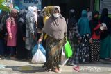 Warga membawa bantuan paket sembako saat penyaluran di Rumah Anak Nanggroe (Ruman) Aceh,  Desa Punge Blang Cut, Banda Aceh, Aceh, Rabu (30/3/2022). Sejumlah paket sembako yang berasal dari sumbangan para donatur berupa beras, minyak goreng dan telur ayam yang diberikan kepada fakir miskin tersebut  untuk memenuhi kebutuhan bulan ramadhan 1443 Hijriyah. ANTARA FOTO/Ampelsa