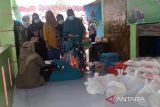 Warga antri memperoleh bantuan paket sembako saat penyaluran di Rumah Anak Nanggroe (Ruman) Aceh,  Desa Punge Blang Cut, Banda Aceh, Aceh, Rabu (30/3/2022). Sejumlah paket sembako yang berasal dari sumbangan para donatur berupa beras, minyak goreng dan telur ayam yang diberikan kepada fakir miskin tersbeut untuk memenuhi kebutuhan bulan ramadhan 1443 Hijriyah. ANTARA FOTO/Ampelsa