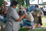 Pembina  Rumah Anak Nanggroe (Ruman) Aceh, Ahmad Arief (kiri) menyerahkan bantuan paket sembako kepada  fakir miskin di Desa Punge Blang Cut, Banda Aceh, Aceh, Rabu (30/3/2022). Sejumlah paket sembako yang berasal dari sumbangan para donatur berupa beras, minyak goreng dan telur ayam yang diberikan kepada fakir miskin tersbeut untuk memenuhi kebutuhan bulan ramadhan 1443 Hijriyah. ANTARA FOTO/Ampelsa