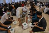 Petugas membagikan sajian berbuka puasa untuk masyarakat umum di kompleks Masjid Istiqlal, Jakarta, Minggu (3/4/2022). Kegiatan buka puasa bersama yang digelar pertama kali setelah vakum dua tahun saat pandemi COVID-19 tersebut menyediakan 3.000 paket makanan untuk umat islam selama bulan suci Ramadhan tahun ini. ANTARA FOTO/Aditya Pradana Putra/YU