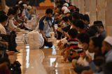 Petugas membagikan sajian berbuka puasa untuk masyarakat umum di kompleks Masjid Istiqlal, Jakarta, Minggu (3/4/2022). Kegiatan buka puasa bersama yang digelar pertama kali setelah vakum dua tahun saat pandemi COVID-19 tersebut menyediakan 3.000 paket makanan untuk umat islam selama bulan suci Ramadhan tahun ini. ANTARA FOTO/Aditya Pradana Putra/YU