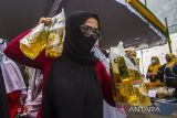 Warga membawa minyak goreng yang dibeli dengan harga murah saat pasar murah Ramadhan di Banjarmasin, Kalimantan Selatan, Selasa (5/4/2022). Bazar dan pasar murah yang diselenggarakan oleh Pemerintah Kota menggunakan Banjarmasin Corporate Social Responsibility (BCSR) tersebut untuk stabilisasi harga pasaran karena beberapa komoditas mengalami kenaikan harga di pasar serta untuk mendekatkan pelayanan kepada masyarakat dengan harga distributor. Foto Antaranews Kalsel/Bayu Pratama S.