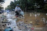 Warga menerjang banjir di Kawasan Gedebage, Bandung, Jawa Barat, Rabu (6/4/2022). Hujan dengan intensitas tinggi di berbagai titik di Kota Bandung membuat sejumlah wilayah tergenang air yang menyebabkan kemacetan di jalan nasional Soekarno-Hatta. ANTARA FOTO/Raisan Al Farisi/agr
